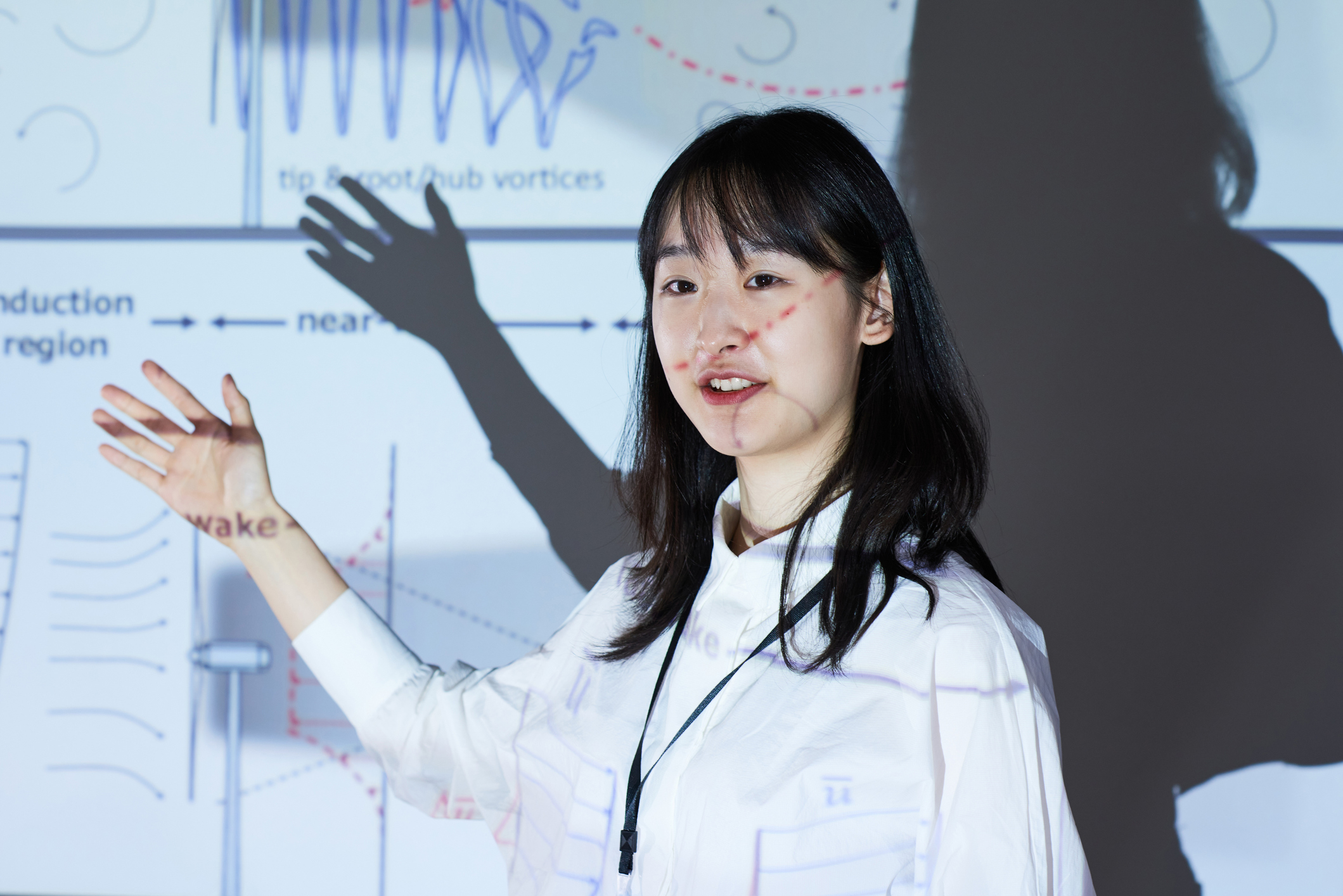 Asian young architect pointing at big monitor with chart and presenting her report at conference